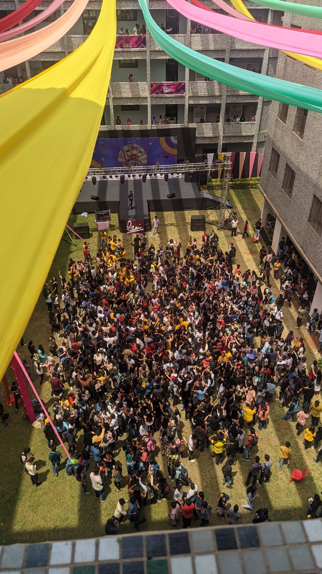 Students gathered for a college club event with colorful decorations and a stage.